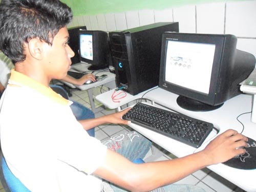 Menino utilizando o computador na escola