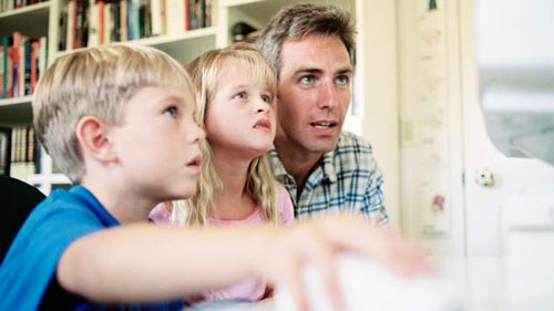 Pai e filhos usando o computador