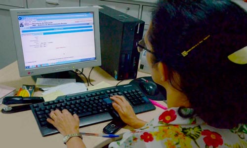 Senhora acessando Seduc TO no computador